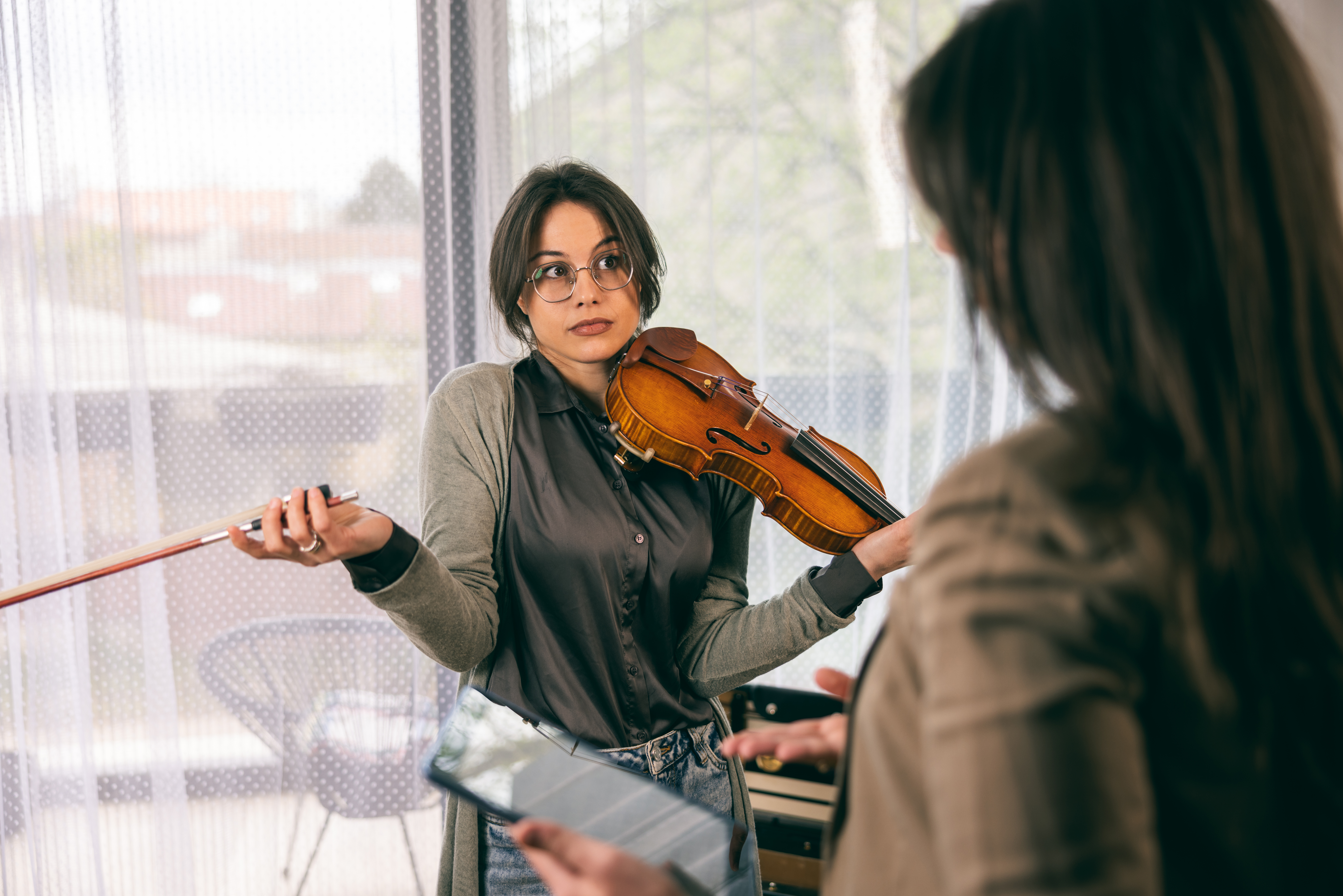 Music student with violin during lesson, highlighting scheduling confusion solved by Opus1 make-up lesson automation