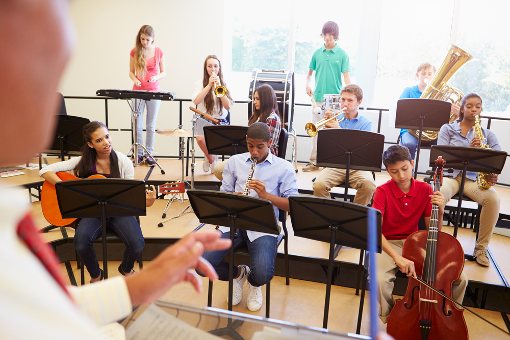 Pupils,Playing,Musical,Instruments,In,School,Orchestra Highschool band class - kids with various musical intruments on risers
